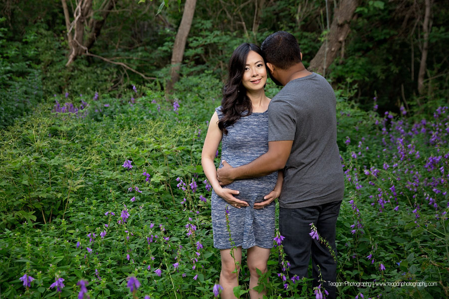 A mixed race couple are expecting their first baby and snuggle during an Edmonton maternity photography session. 