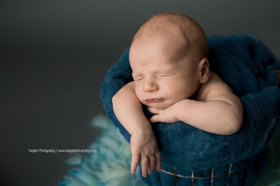 An Edmonton newborn boy sleep in a bucket with a blue blanket
