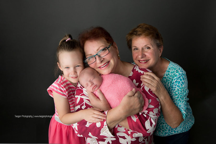Happy grandparents cuddle their two granddaughters