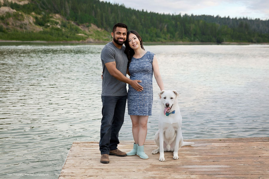 A mixed race couple pose on a dock along the North Saskatchewan River in Edmonton for maternity photos. 
