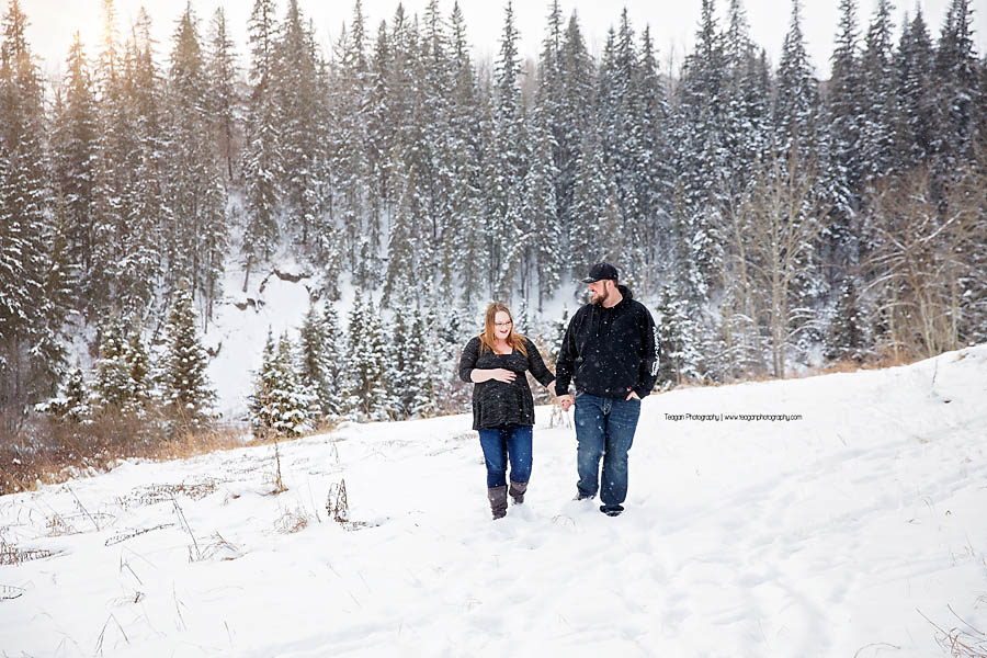 Pregnant mother and husband walking together during Edmonton winter maternity photography session