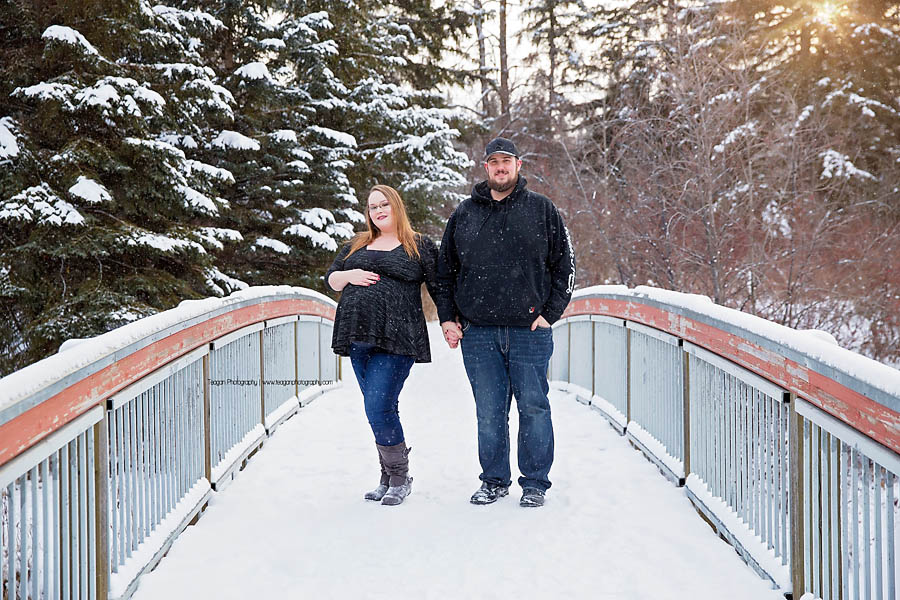 YEG maternity photographer capturing outdoor winter pregnancy photos with snowflakes falling