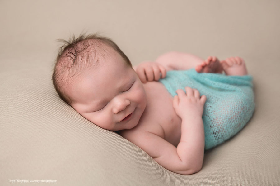 Sleep smiles from an Edmonton newborn baby boy during a newborn photography session