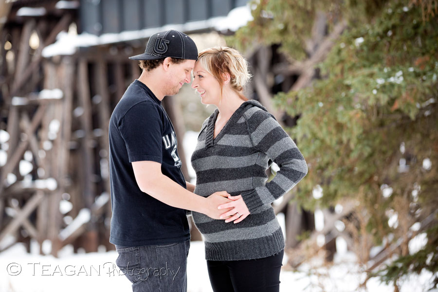 A couple with skater attire pose for winter maternity photos in St Albert