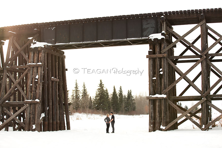 A couple expecting their first child pose together on the frozen Sturgeon river in St Albert