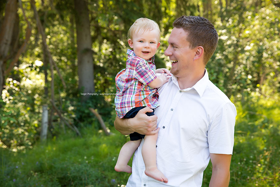 A dad laughs with his one year old son during a family photo shoot in Edmonton