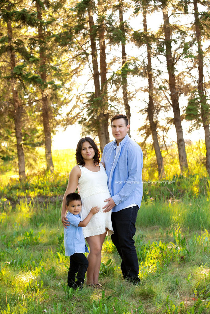 The summer sun filters through the trees during  an Edmonton maternity photoshoot