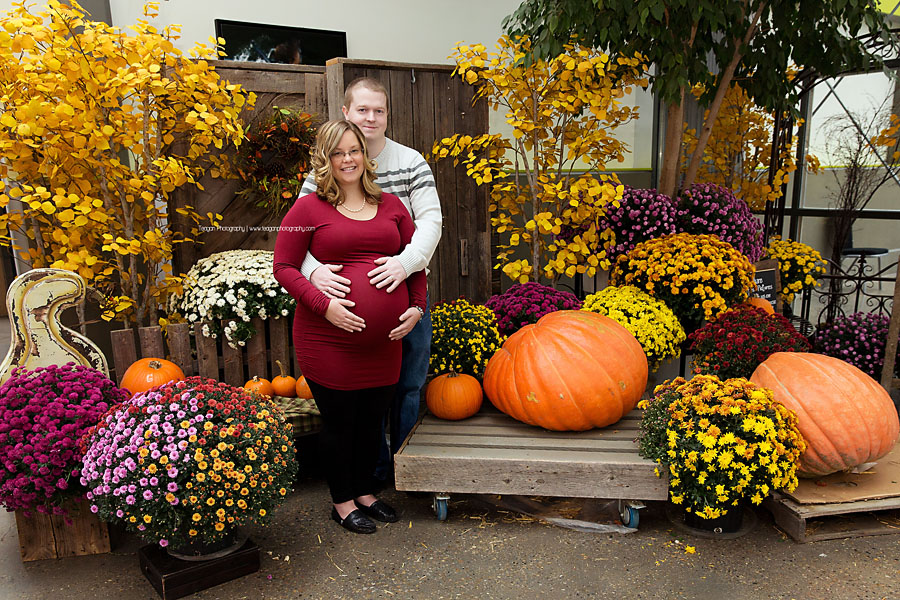 Posed in front of the fall foliage is a pregnant Edmontoncouple 