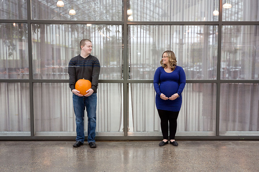 A husband holds a pumpkin next to his pregnant wife at the Enjoy Centre in St Albert during a maternity photoshoot
