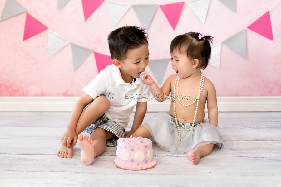 Celebrating her first birthday with a caks smash photo shoot is an Asian girl