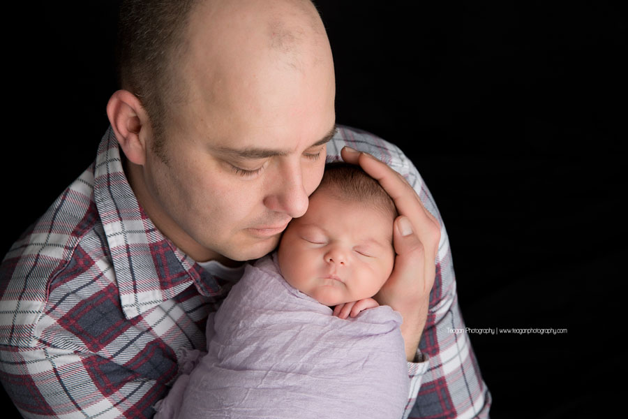 A father holds his baby during an Edmonton newborn photography session