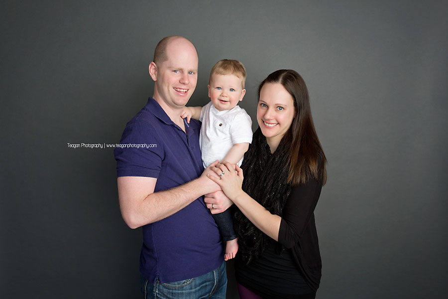 Parents hold their one year old boy during his birthday photo shoot