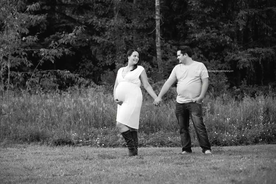 A husband and wife are expecting their first baby and celebrate with Edmonton maternity photos in the summer along the Millcreek stream