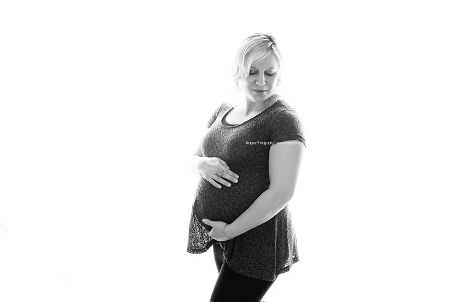 Wearing black lace is a pregnant woman during a Edmonton Studio photography session  