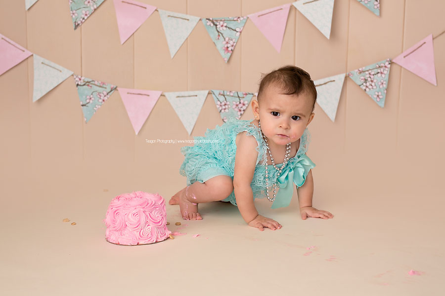 A one year old girl celebrates her first birthday with a pink and robin's egg blue cake smash in Edmonton