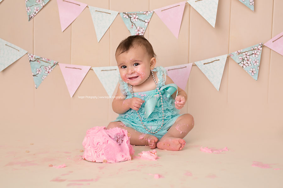 A one year old girl celebrates her first birthday with a pink and robin's egg blue cake smash in Edmonton