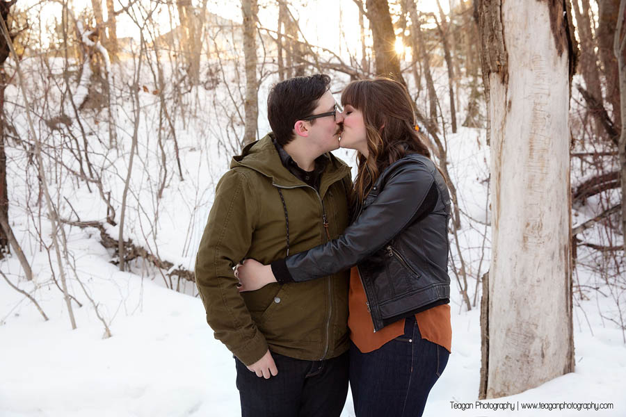 A newly engaged couple kiss during a photoshoot in winter
