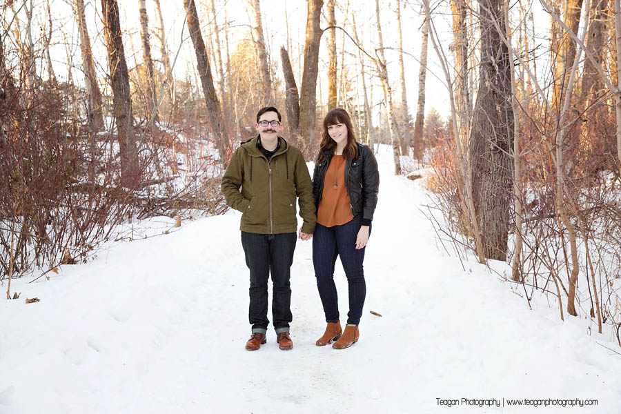 A newly engaged couple stand together during a winter photo session in St Albert 