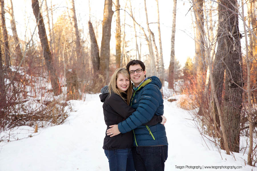 A newly engaged couple stand together during a winter photo session in St Albert 