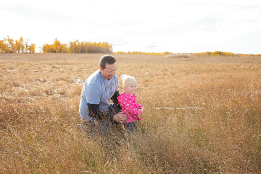 A father plays with his daughter in an Edmonton field