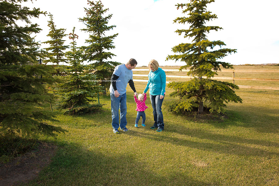 Parents play with their daughter in an Edmonton field