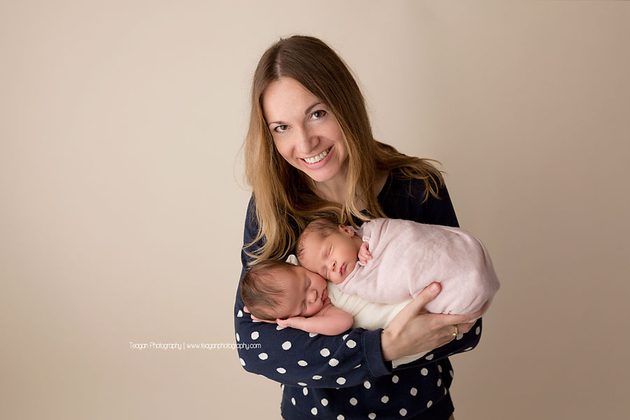 An aunt holds her new nieces during an Edmonton twin newborn photoshoot