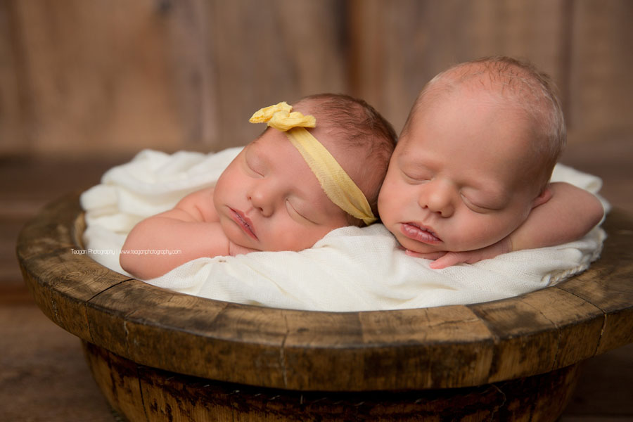 Newborn twins in Edmonton sleep in a wooden bowl together