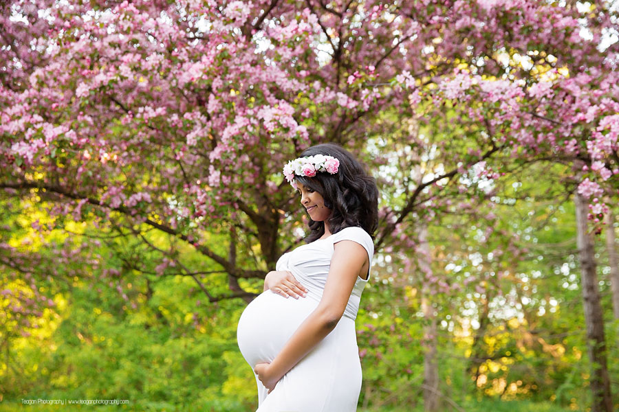 A background of sunshine and Edmonton cherry blossoms trees for a pregnant mother's maternity photo shoot 