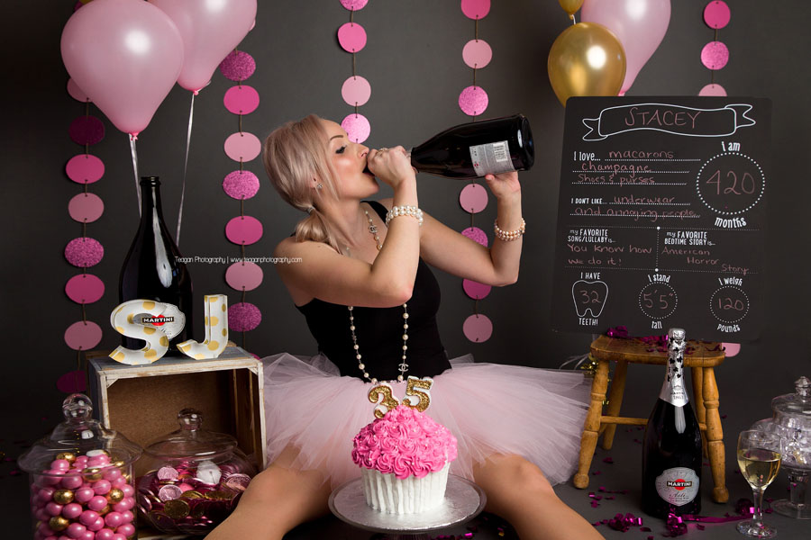 A birthday girl drinks directly out ot the champagne bottle during her adult cake smash photo shoot in Edmonton