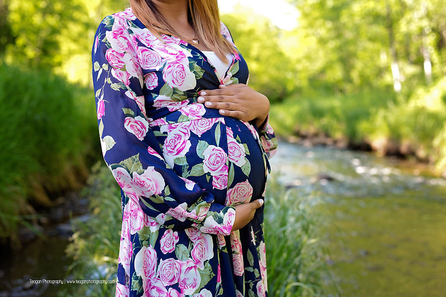 Pregnant mother posing elegantly by a shallow creek in the Edmonton Millcreek ravine during summer