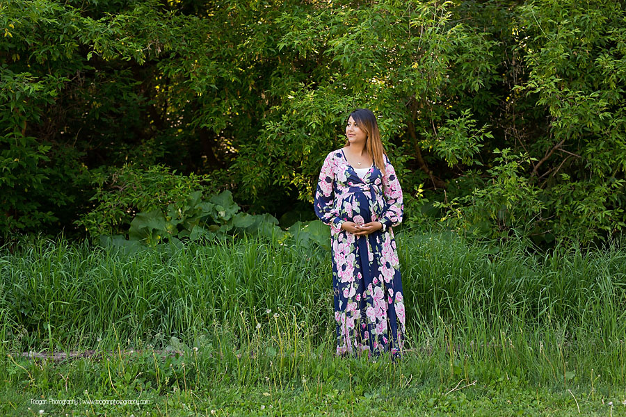 Pregnant mother posing elegantly by a shallow creek in the Edmonton Millcreek ravine during summer