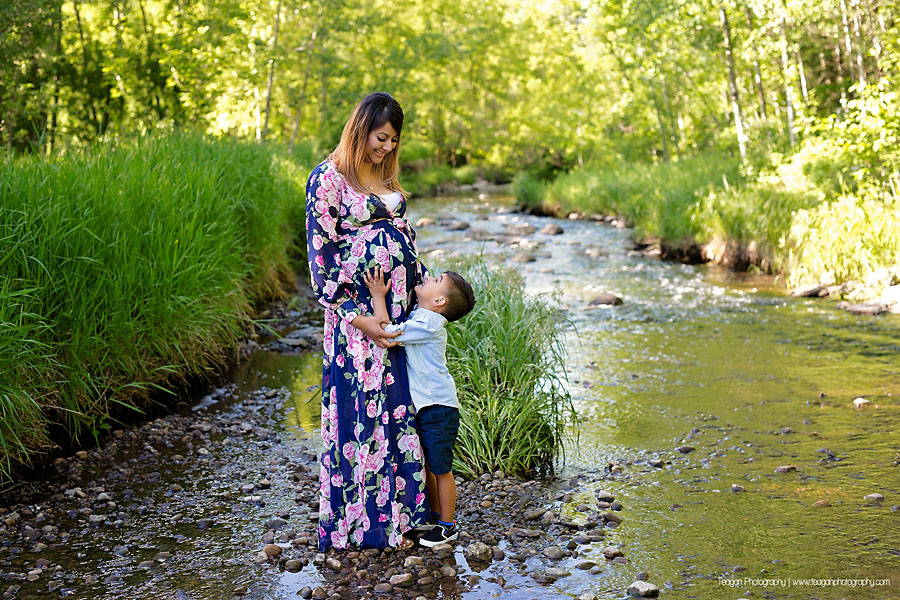 Pregnant mother posing elegantly by a shallow creek in the Edmonton Millcreek ravine during summer